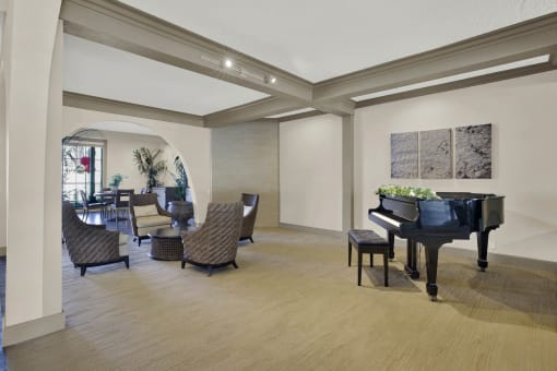 a living room with a piano and a dining room with chairs at Copa Ladeene Apartments, Torrance California