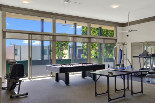 a game room with a pool table and a gym with windows at Copa Ladeene Apartments, Torrance, CA 90505