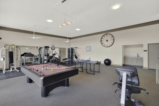 a gym with a pool table and a clock at Copa Ladeene Apartments, Torrance, 90505
