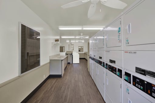 a classroom with white cabinets and counters and a ceiling fan at Copa Ladeene Apartments, Torrance, 90505