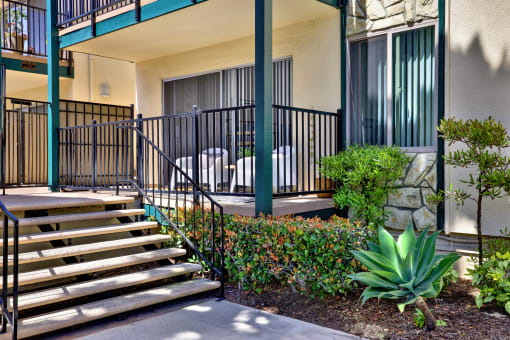 steps leading up to a building with a patio and plants at Copa Ladeene Apartments, Torrance, CA