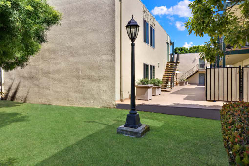 a yard with a lamp post in front of a house  at Copa Ladeene Apartments, Torrance, CA 90505