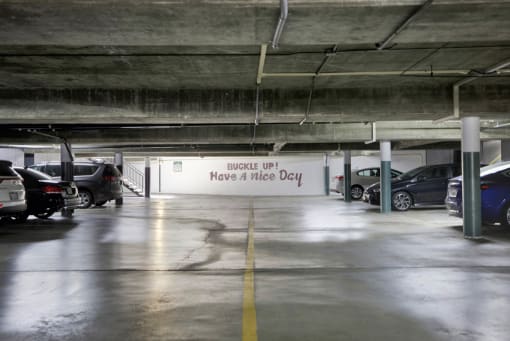 a parking garage with cars and a sign that says have a nice day at Copa Ladeene Apartments, Torrance, CA