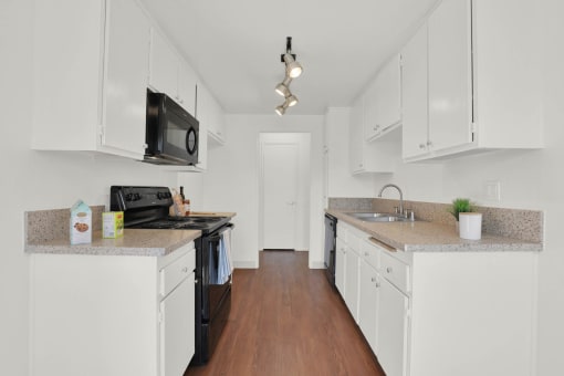 a kitchen with white cabinets and a counter top at Copa Ladeene Apartments, Torrance, 90505