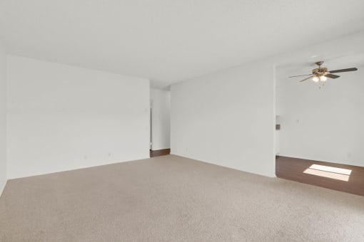 an empty living room with white walls and a ceiling fan at Copa Ladeene Apartments, Torrance, 90505