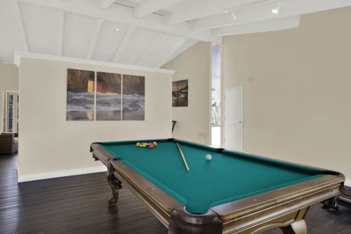 a games room with a pool table and paintings on the wall at Copa Triana Apartments, Torrance, CA 90505