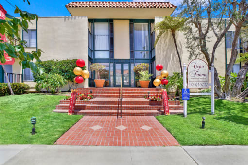 the front of a building with stairs and a sign in front at Copa Triana Apartments, California