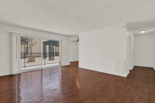 the living room and dining room with wood flooring and a balcony at Copa Triana Apartments, Torrance, 90505