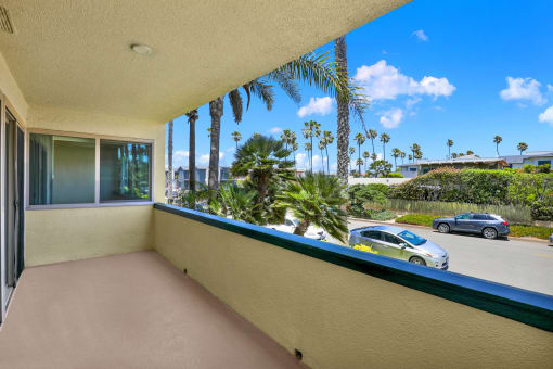 a balcony with a view of a street and palm trees at Royal Towers Apartments, Redondo Beach, CA, 90277