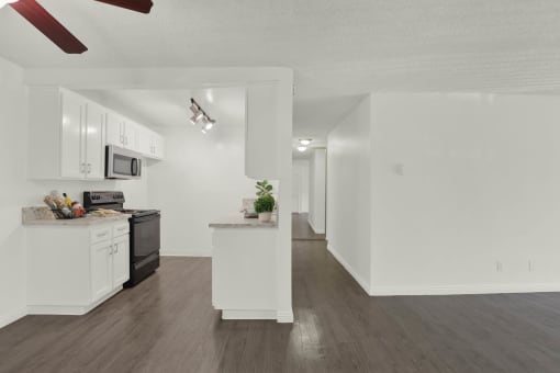a kitchen with white cabinets and a counter top at Willow Tree Apartments, Torrance, CA