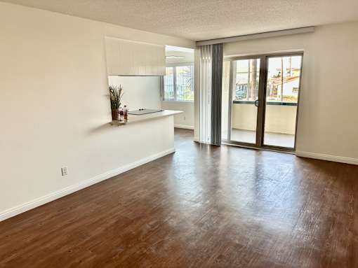A room with wooden floors and a window with blinds at Royal Towers Apartments, Redondo Beach, CA, 90277