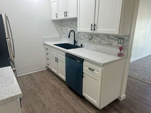 A kitchen with white cabinets and a blue dishwasher. at Camino de Oro Apartments, Torrance, CA, 90505