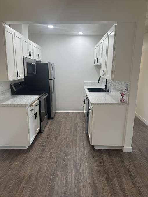 A kitchen with white cabinets and a black fridge. at Camino de Oro Apartments, Torrance, CA, 90505