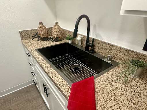 A kitchen counter with a sink and a red towel at Willow Tree Apartments, California, 90505