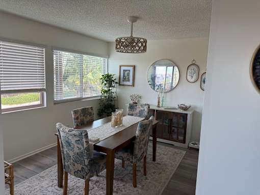 A dining room with a table and chairs.