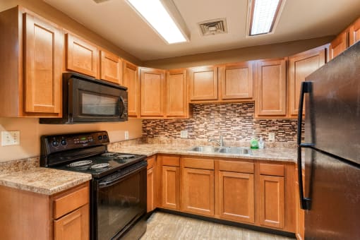 a kitchen with black appliances and wooden cabinets