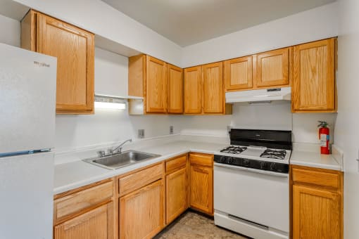 a kitchen with white appliances and wooden cabinets