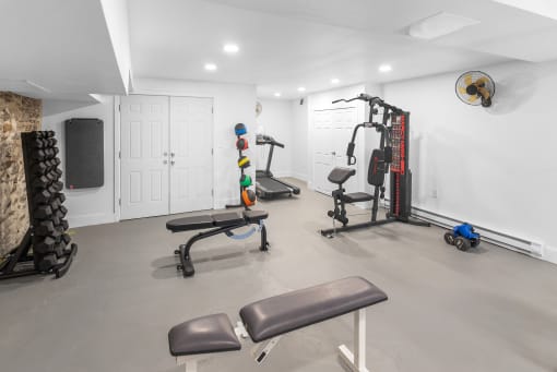 a gym with weights and exercise equipment in a room with white walls