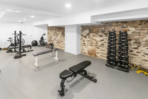 a gym with a stone wall and weights machines