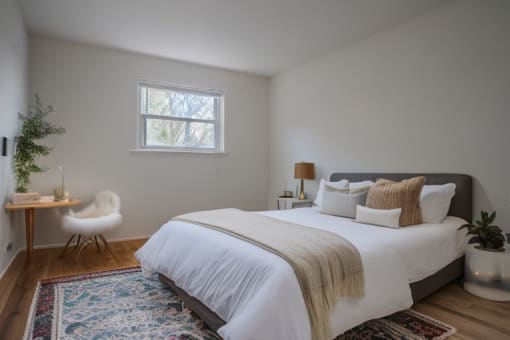 a bedroom with a bed and a chair and a window