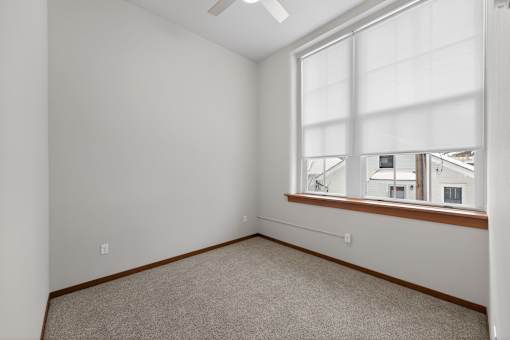 A room with a window and a ceiling fan.
