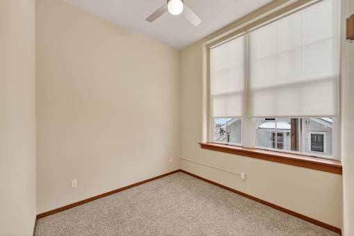 A room with a window and a ceiling fan.