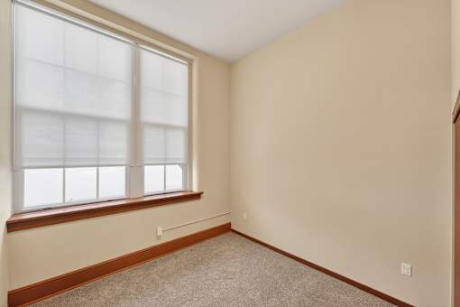 A room with a window and carpeted floor.
