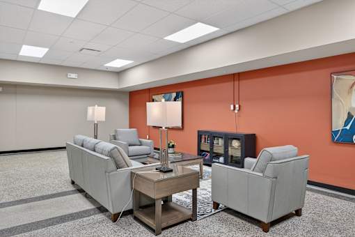 A living room with a grey couch, a coffee table, and a lamp.