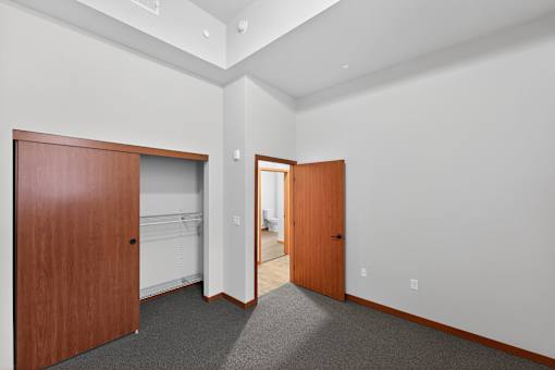 A room with two wooden doors and carpeted floor.