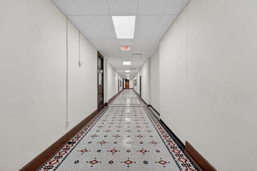A long hallway with a tiled floor and white walls.