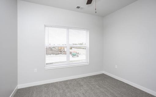 A room with a window and a ceiling fan.