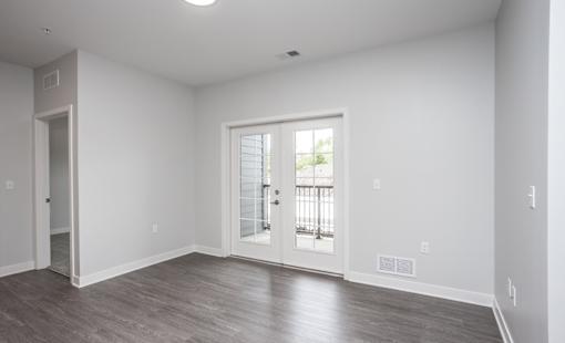 A room with a sliding glass door leading to a balcony.