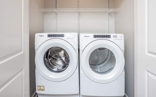 Two white washing machines in a laundry room.