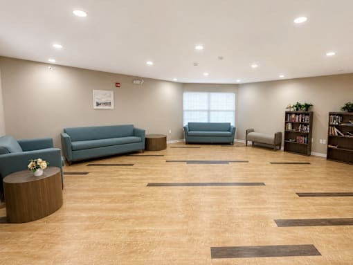 A spacious waiting room with blue couches and a coffee table.