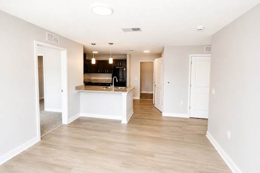 A kitchen with white cabinets and a wooden floor.