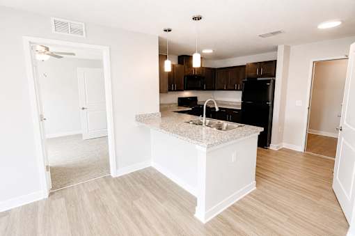 A kitchen with a black refrigerator and white cabinets.