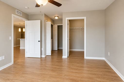 A room with a ceiling fan and wooden flooring.