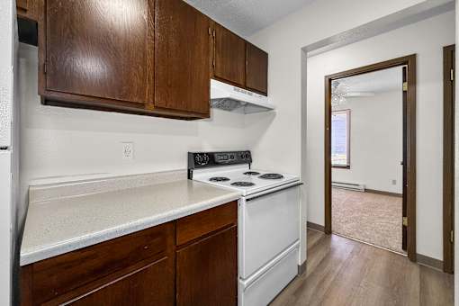 A kitchen with white appliances and wooden cabinets.