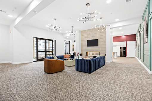 A large room with a carpeted floor and a flat screen TV mounted on the wall.