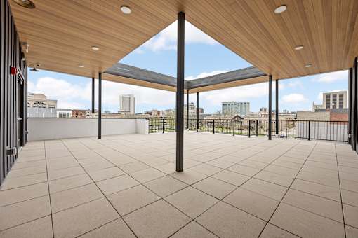 A patio with a wooden roof and tiled floor.
