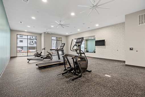 A spacious gym with treadmills and elliptical machines.