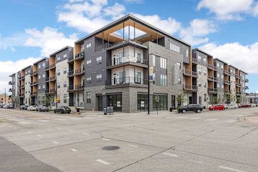 A large apartment building with a parking lot in front.