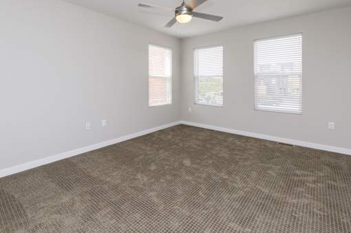 A room with a ceiling fan and carpeted floor.at 5Fifty5, Des Moines Iowa  