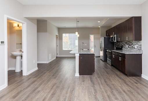 an empty kitchen with wood flooring and stainless steel appliances at 5Fifty5, Des Moines  