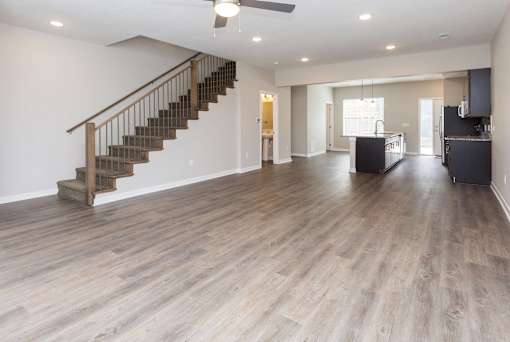 a living room with a staircase and a hard wood floor at 5Fifty5, Des Moines Iowa  