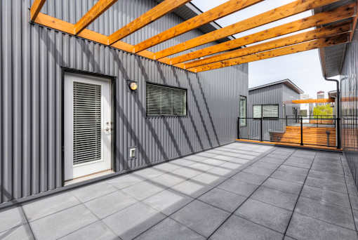 a patio with a wooden roof and a door at 5Fifty5, Des Moines, IA  