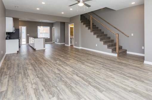 an empty living room with a hard wood floor and a staircase at 5Fifty5, Des Moines, IA 50309  