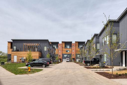 a row of new apartment buildings with cars parked on the street at 5Fifty5, Iowa, 50309