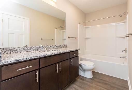 a bathroom with a large mirror and a toilet and a shower at 5Fifty5, Des Moines  