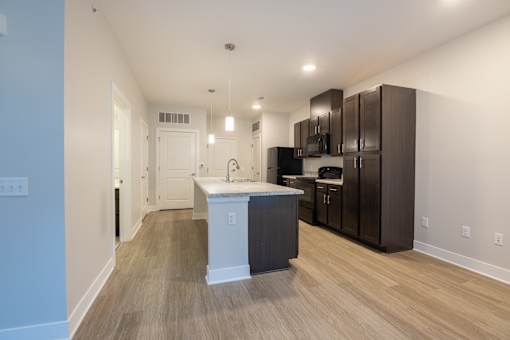 A kitchen with a white island and dark brown cabinets.